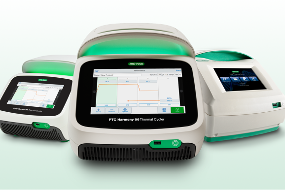 Three advanced thermal cyclers are displayed, each with digital screens showing graphs and data.