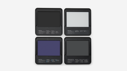 Four black-framed Bio-Rad imaging trays form a 2x2 grid on a white background. Their distinct centers are labeled: Blot Tray (black), White Tray, Blue Tray, and UV/Stain-Free Tray (dark grey).