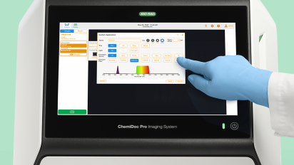 close up of a person in a blue lab glove touches the screen of a Bio-Rad ChemiDoc Pro Imaging System.